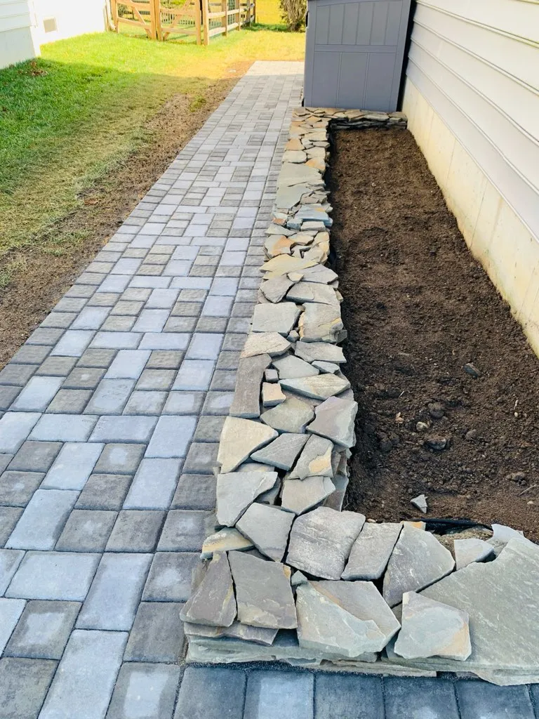 A paver walkway finished with a natural stone border